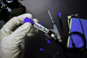 insulina prueba texto con sangre muestra. parte superior ver aislado en negro antecedentes. cuidado de la salud médico concepto foto