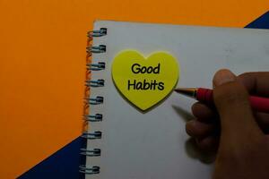 Good Habits write on sticky notes isolated on Office Desk photo