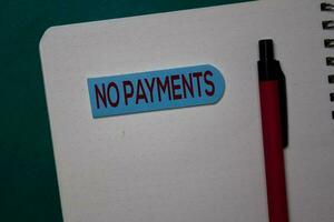 No Payments write on a sticky note isolated on green background. photo