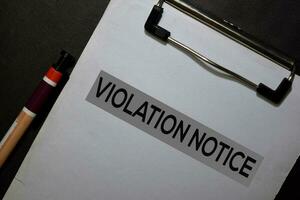 Violation Notice write on a paperwork isolated on black table. photo