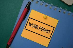 Work Permit write on a sticky note isolated on green background. photo