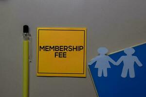 Membership Fee write on sticky note isolated on Office Desk. photo