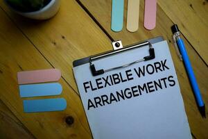 Flexible Work Arrangements write on a paperwork isolated on wooden background. photo