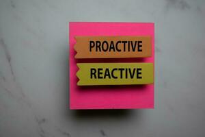 Procative Vs Reactive write on sticky note isolated on Office Desk photo