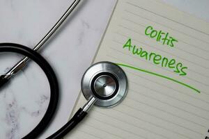 Colitis Awareness write on a book isolated wooden table. photo