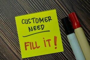 Customer Need - Fill It write on sticky notes isolated on office desk. photo