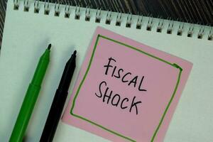 Fiscal Shock write on sticky notes isolated on Wooden Table. photo