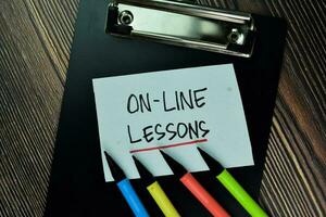 On-Line Lesson write on sticky note and isolated on Wooden Table. Educational Concept photo