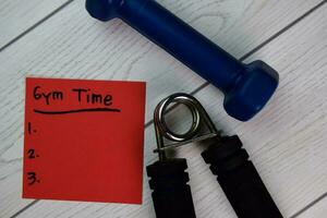 Gym Time write on sticky notes and supported by additional services isolated on Wooden Table. photo