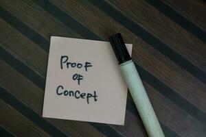Proof of Concept write on sticky notes isolated on Wooden Table. photo