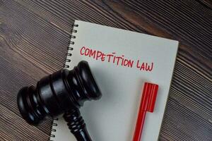 Competition Law write on a book isolated on Wooden Table. photo