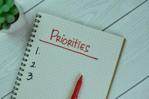 Set Priorities write on a book isolated on Wooden Table. photo