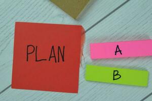 Concept of Choose Plan A to B write on sticky notes isolated on Wooden Table. photo