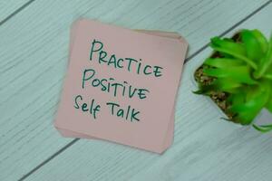 Concept of Practice Positive Self Talk write on sticky notes isolated on Wooden Table. photo