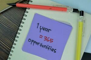 Concept of 1 Year  365 Opportunities write on sticky notes isolated on Wooden Table. photo