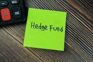 Concept of Hedge Fund write on sticky notes isolated on Wooden Table. photo