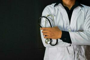 Physician or doctor holding stethoscope. Listening story patient concept. Isolated on black background photo