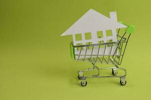 House put in a shopping cart on the desk. Savings for home, buying houses, sell houses, real estate or housing benefit concept. photo