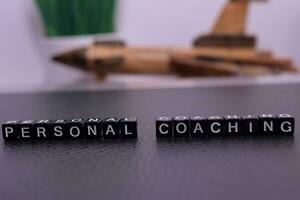 Personal Coaching on wooden blocks. Cross processed image with business concept on White background photo