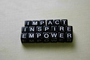 Impact - Inspire - Empower on wooden blocks. Business and inspiration concept photo