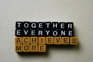 Together Everyone Achieves More on wooden blocks. Business and inspiration concept photo