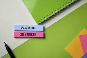 We Are on Strike text on top view office desk table of Business workplace and business objects. photo
