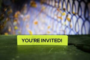 You're Invited on the sticky notes with bokeh background photo