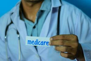 Doctor holding a card with text medicare. Medical and healthcare concept. photo