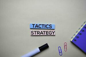 Tactics and Strategy text on sticky notes with office desk concept photo