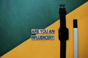 Are You An Influencer text on top view color table background. photo