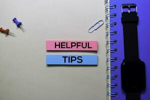 Helpful Tips text on sticky notes isolated on office desk photo