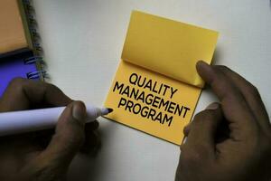 Quality Management Program text on sticky notes isolated on office desk photo