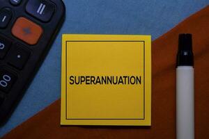 Superannuation on sticky Notes isolated on Office Desk background. photo