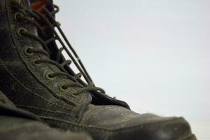 Close up of a brown old boots isolated on white background photo