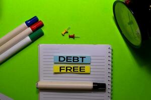 Debt Free write on sticky notes. Isolated on green table background photo