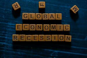 Global Economic Recession on wooden cubes. On table background photo