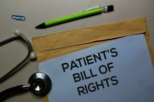 Patient's Bill of Rights text on document above brown envelope and stethoscope. Healthcare or medical concept photo