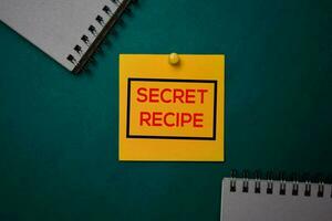 Secret Recipe write on a sticky note isolated on green background. photo
