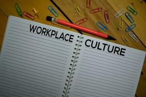 Workplace or Culture write on a book isolated on wooden background. photo