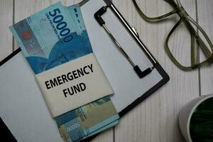 Emergency Fund text and Indonesian Rupiah isolated on Office Desk. photo