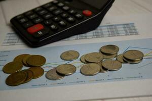 Calculator and the stack of coint isolated on office desk. calculating salary or tax concept photo