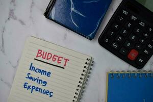 Budget, Income, Saving, Expenses write on a book isolated wooden table. photo