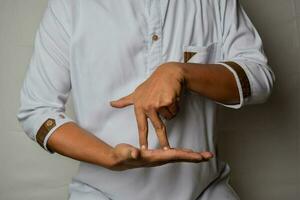 Close up Asian man shows hand gestures it means STAND isolated on white background. American sign language photo