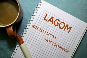 LAGOM. Not Too Little. Not Too Much text on the book isolated on office desk background photo