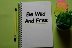 Be Wild and Free write on a book isolated on office desk. photo