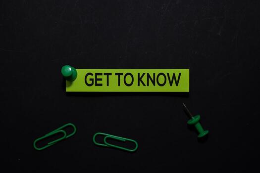 Get To Know write on Sticky Notes. Top view isolated on black background. photo