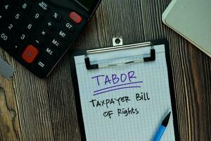 TABOR - Taxpayer Bill of Rights write on a paperwork isolated on Wooden Table. Business or Financial Concept photo