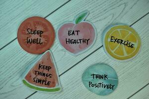 Healthy Lifestyle Concept and keywords write on sticky notes isolated on Wooden Table. photo