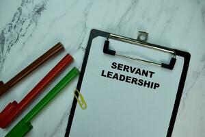 Servant Leadership write on paperwork isolated on Wooden Table. photo