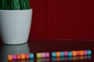 Stress and relaxation text at colorful wooden block on red background. Desk office and education concept photo